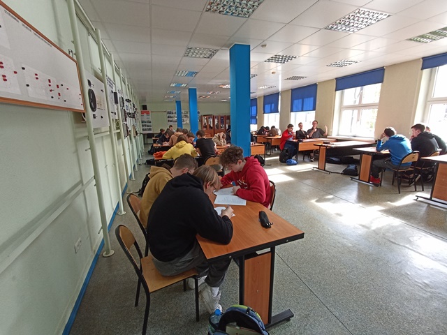 Uczestnicy konkursu języka niemieckiego Turbolandeskunde siedzą przy stolikach i rozwiązują test