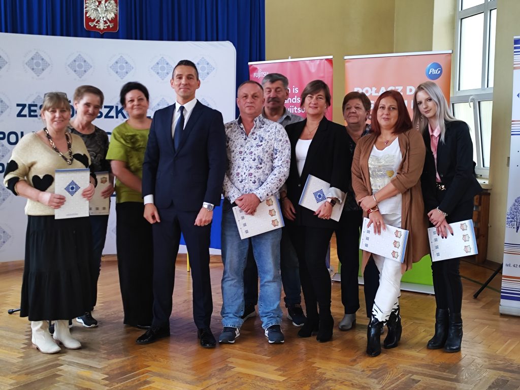 Nagrodzeni pracownicy obsługi z dyrektorem na tle baneru ZSP w Łodzi