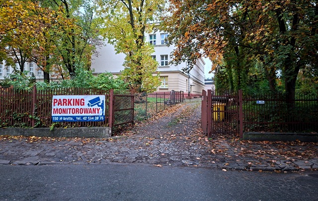 Brama na tle budynku szkoły - wjazd od ul. Skrzywana