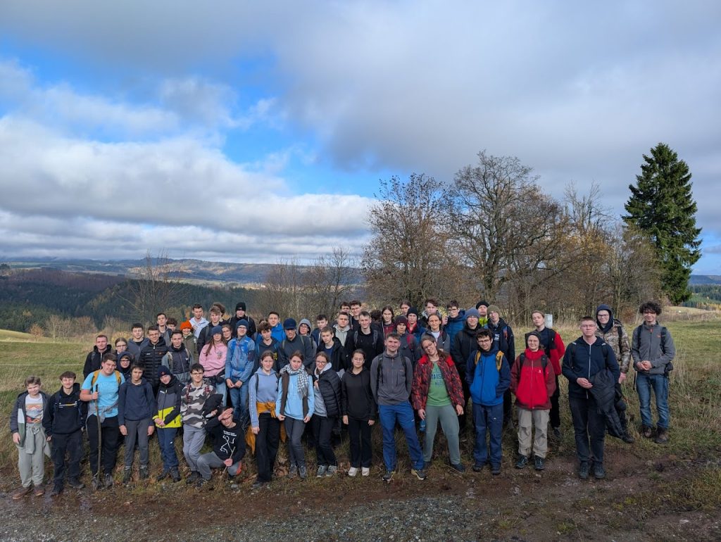 Grupa uczestników IX Uniwersyteckiego Obozu Olimpiady Matematycznej na tle górskiego pleneru