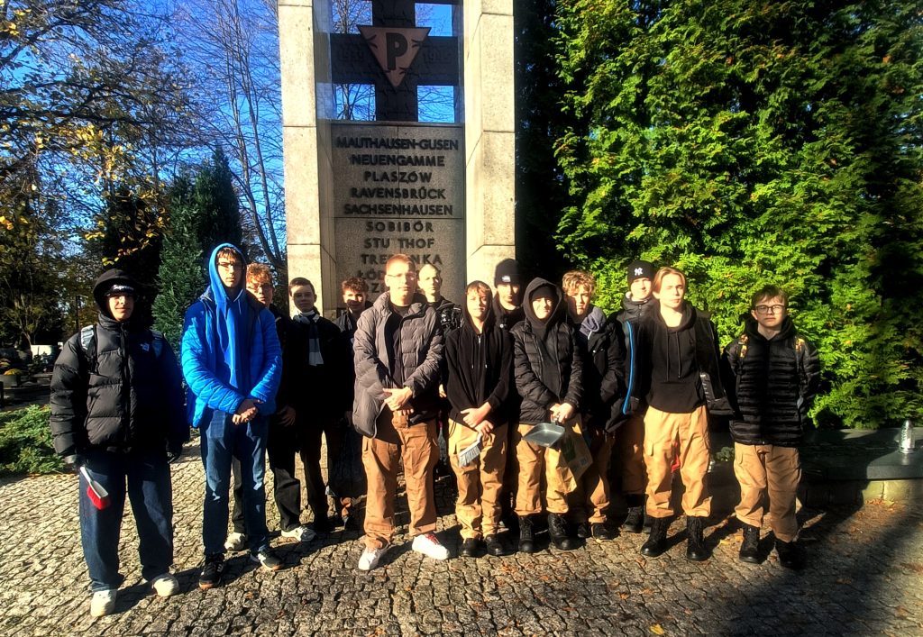 Zdjęcie grupowe uczniów ZSP pod pomnikiem na cmentarzu na Dołach