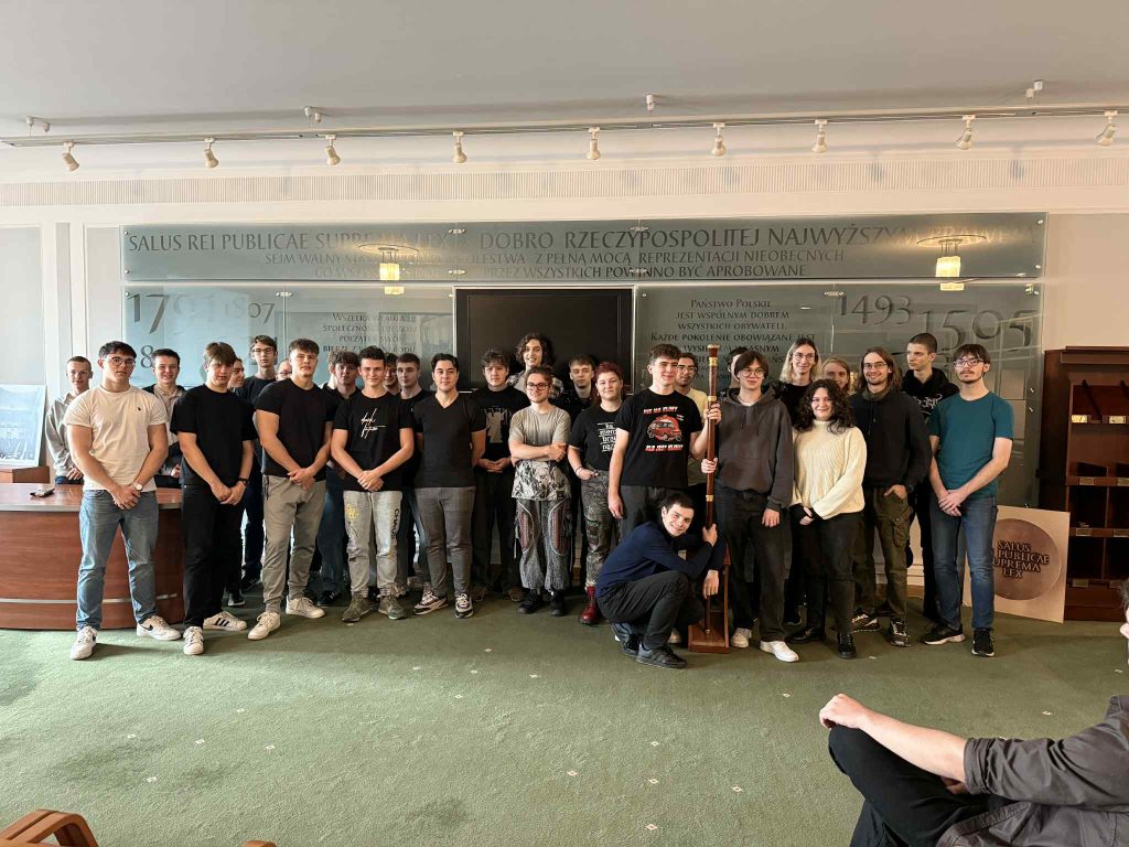 Zdjęcie zbiorowe uczniów na tle napisu Dobro Rzeczpospolitej Najwyższym Prawem z wycieczki do sejmu
