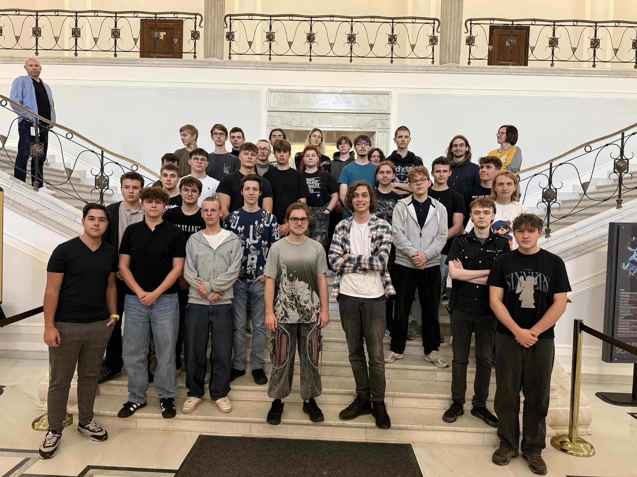 Zdjęcie zbiorowe uczniów na tle schodów z wycieczki do sejmu