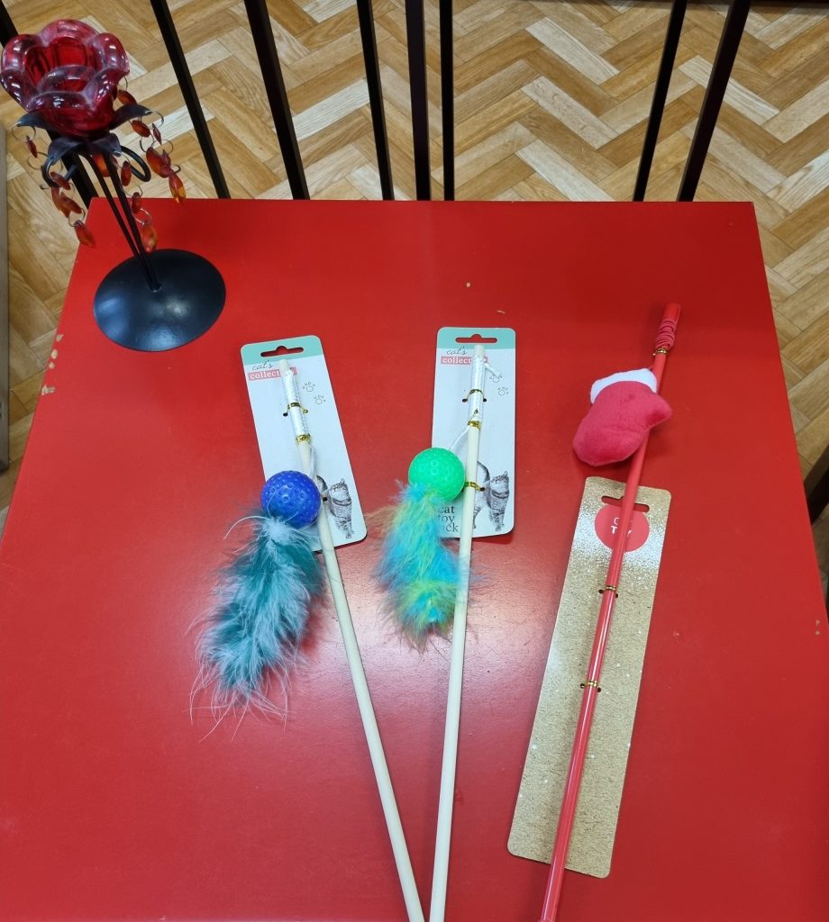 Na czerwonym stoliku zabawki dla kota