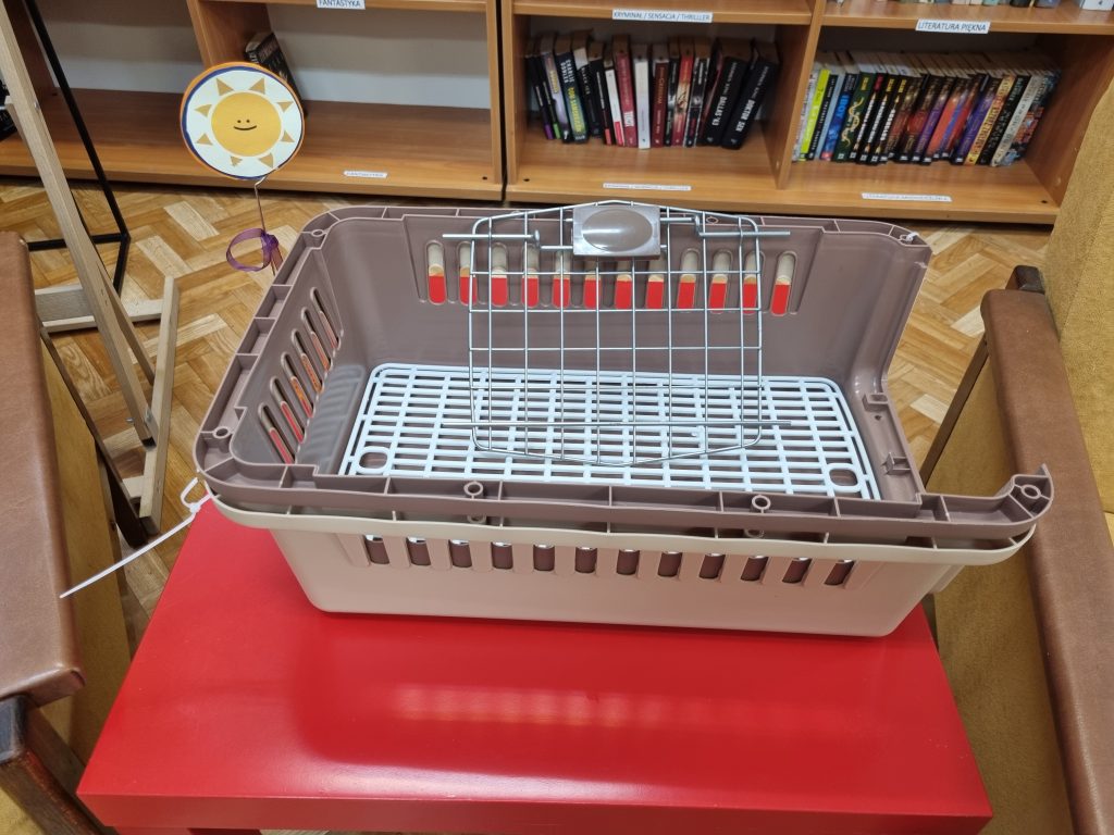 Na czerwonym stoliku transporter dla kota