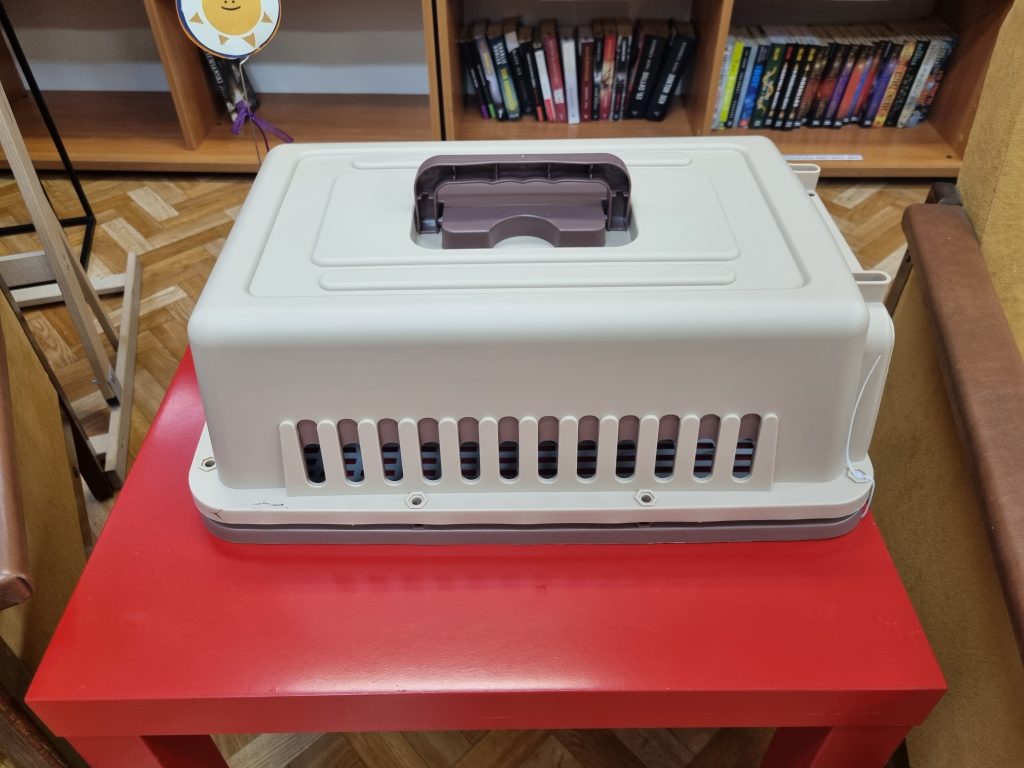 Na czerwonym stoliku transporter dla kota