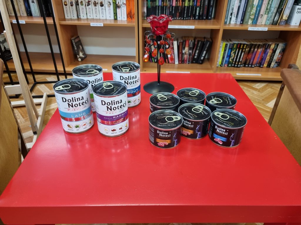 Na czerwonym stoliku puszki dla kota