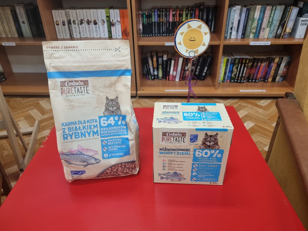 Na czerwonym stoliku saszetki i sucha karma dla kota