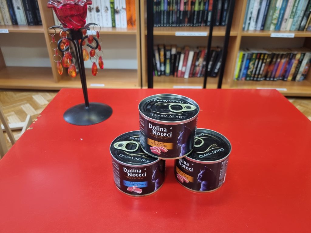 Na czerwonym stoliku puszki dla kota