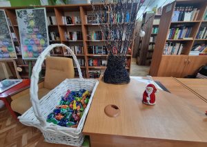 Dekoracja świąteczna i kosz z cukierkami w bibliotece szkolnej