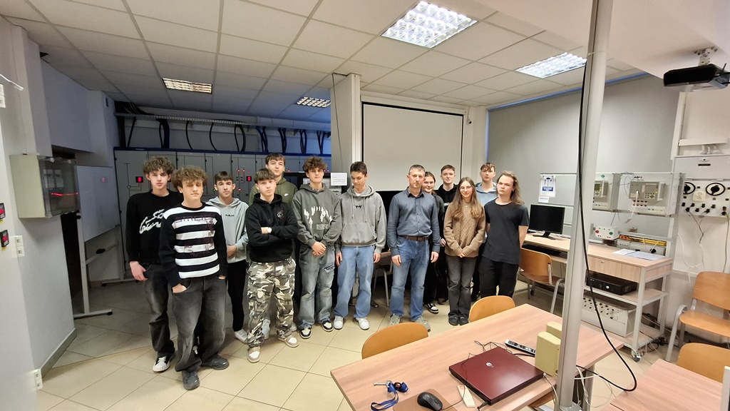 Grupa młodzieży z nauczycielem w laboratorium PŁ