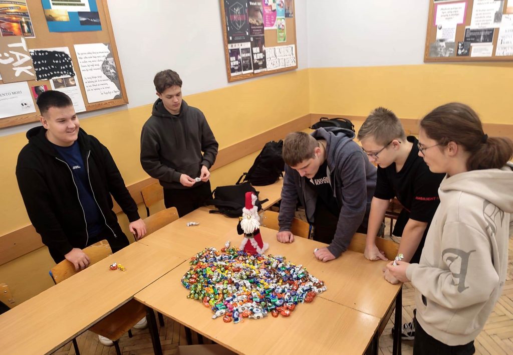 Młodzież częstuje się cukierkami wyłożonymi na ławkach szkolnych 