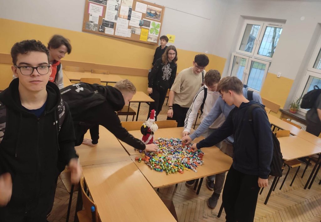 Młodzież częstuje się cukierkami wyłożonymi na ławkach szkolnych 