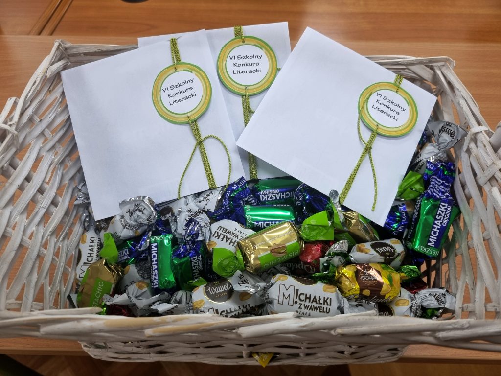 Koszyk z cukierkami i kopertami z emblematem konkursu