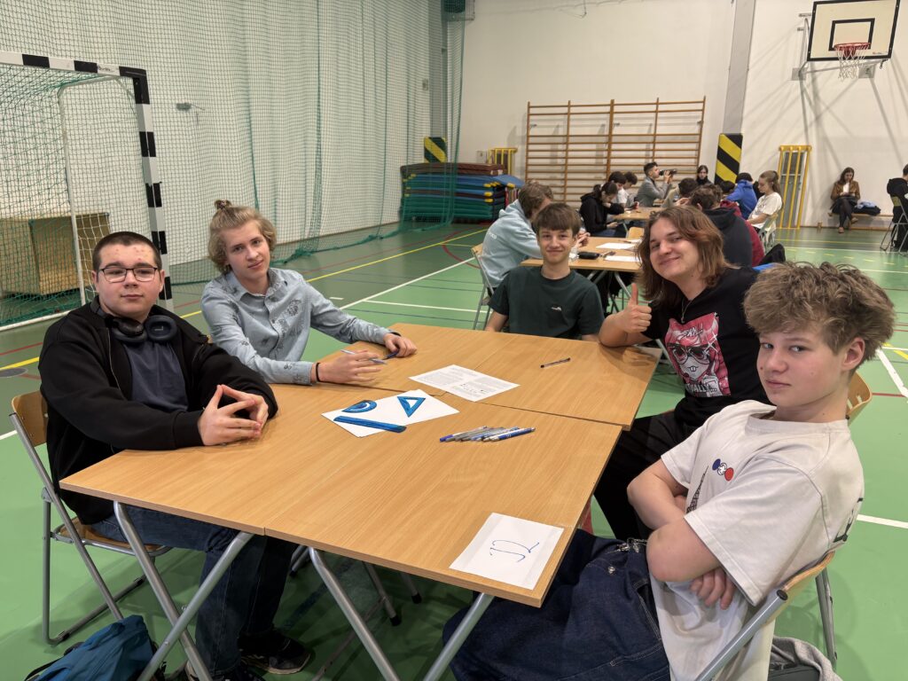 Uczniowie przy stoliku konkursowym